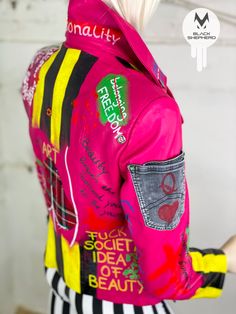 the back of a woman's pink jacket with writing on it and an image of a