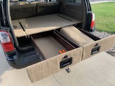 an open trunk in the back of a van with its doors open and seats folded down