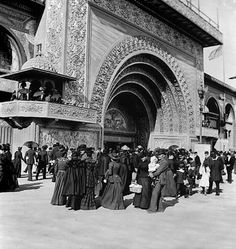 an old black and white photo of people standing in front of a building with arches