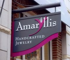 the sign for amarlis handcrafted jewelry hangs from the side of a building