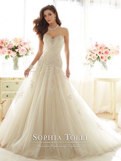 a woman in a wedding dress standing by a window