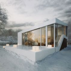 a white house sitting in the middle of a snow covered field with lots of windows