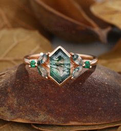 a close up of a ring on top of a rock with leaves in the background