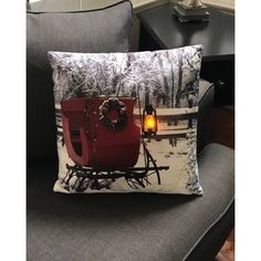 a christmas pillow with a sleigh and wreath on it sitting on a chair