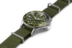 Sized to fit almost any wrist, the 37mm Khaki Navy Scuba Quartz features a total green look, with its unidirectional bezel made of aluminum, ultra-readable dial and a NATO textile strap. The hands and hour indexes on the deep military green dial are treated with Super-LumiNova® for optimal legibility. Appealing and ubiquitous, the green colorway adds an edge to the Khaki Navy Scuba, making it a timeless companion for any challenge, from aquatic explorations to urban adventures. Hamilton Watch Khaki, Hamilton Jazzmaster, Hamilton Khaki, Hamilton Watch, Men In Black, Nato Strap, Watch Gifts, Stainless Steel Band, 100m