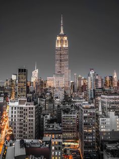 the empire building is lit up at night in new york's cityscape