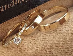 two gold wedding rings sitting on top of a carpeted floor next to a book