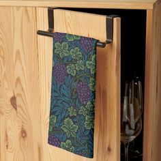 a wooden cabinet with two wine glasses and a towel hanging from it's side