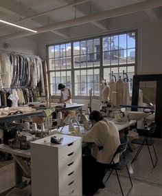 a woman working in a sewing studio with lots of clothes