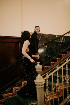 a man and woman are walking down the stairs