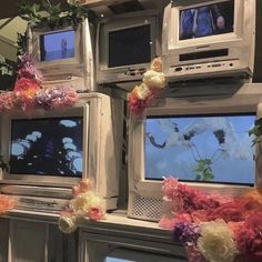 several televisions are decorated with flowers and garland