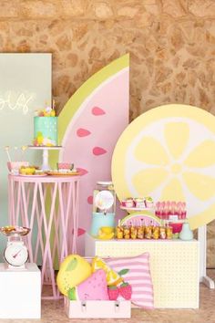 a table topped with lots of cakes and desserts next to a wall mounted clock