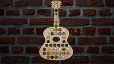 a guitar made out of beer bottle caps hanging on a brick wall