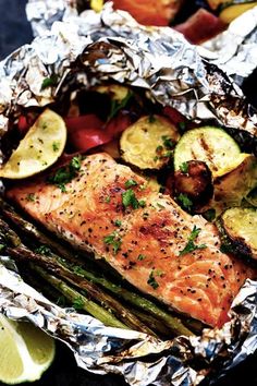 salmon and asparagus wrapped in foil with lemon wedges