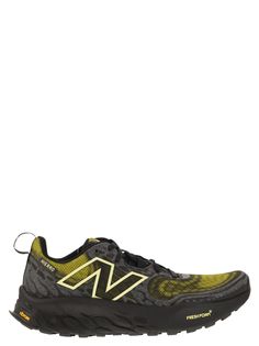 the new balance running shoe in black and yellow