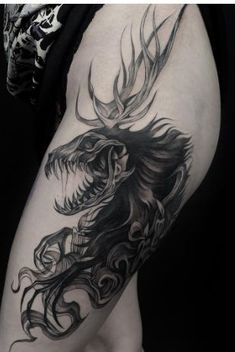 a woman's thigh with a black and white tattoo design on her leg, featuring a dragon