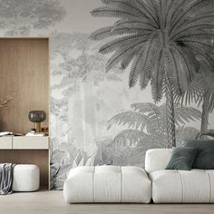 a living room with palm trees on the wall and white couches in front of it