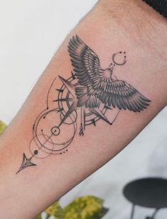 a black and white tattoo on the arm of a person with an arrow in it