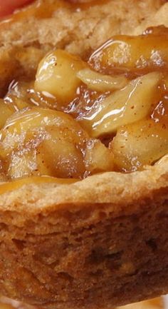 a person holding a piece of bread with bananas on it and caramel sauce in the middle