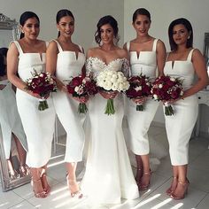 a group of women standing next to each other holding bouquets in front of a mirror