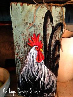 a painting of a rooster on a wooden block