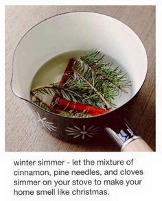 a pot filled with carrots and herbs on top of a wooden table next to a knife