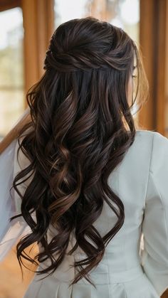 the back of a woman's head with long hair and veil in her hand