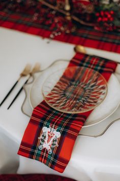 a place setting with red and green plaid napkins