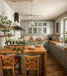 a kitchen filled with lots of wooden furniture and green cupboards next to a sink