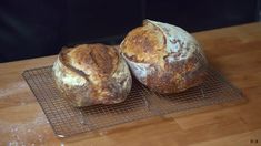 two loaves of bread sit on a cooling rack