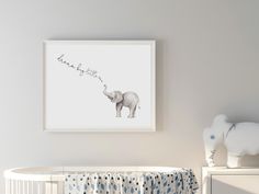 an elephant is standing next to a crib with a baby's name on it