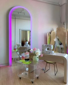 a living room filled with furniture and flowers on top of a hard wood floor next to a large mirror