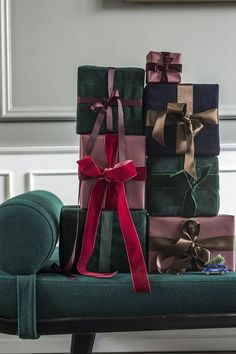 a stack of wrapped presents sitting on top of a green bench