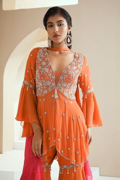 Orange peplum kurta with floral embellishments in pearls, glass beads and white beads. Comes with gharara and ombre dupatta.
Components:3
Pattern:Embellished
Type of Work:Floral Motifs
Neckline:V-Neck
Sleeve Type:Umbrella Sleeves
Fabric:Kurta: Georgette, Gharara: Organza and Crepe, Dupatta: Chiffon, Lining: Satin
Color:Orange
Other Details:
Asymmetric kurta
Back cut-out with tassel tie-up
Ombre dupatta
Occasion:Sangeet - Aza Fashions Peplum Gharara, Seema Thukral, Pleated Dupatta, Embroidery With Pearls, Umbrella Sleeves, Ombre Dupatta, Asymmetric Kurta, Bridal Sari, Fashion Top Outfits