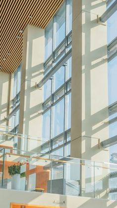 the inside of an office building with glass walls and wood ceilinging, along with large windows