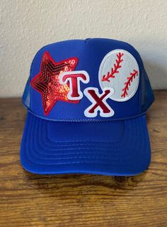 a blue hat with red and white baseballs on it, featuring the texas rangers