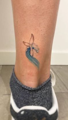 a woman's foot with a small tattoo on the side of her leg,