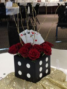 a black box with white polka dots and red roses in it sitting on a table