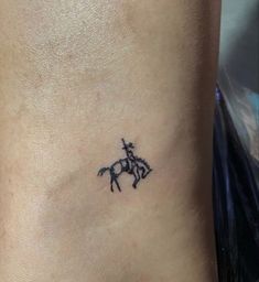 a small black horse tattoo on the side of a woman's neck and leg