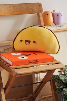 a yellow pillow sitting on top of an orange book