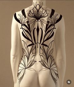 the back of a woman's body painted with black and white flowers on it