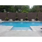 an empty swimming pool with chairs around it and a fence in the backround