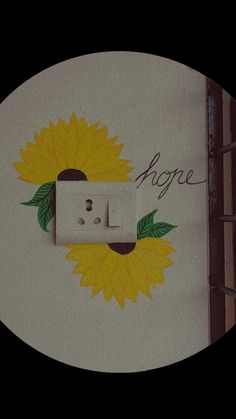 a sunflower painted on the side of a wall with an electrical outlet in it