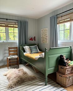 a child's bedroom with a green bed and striped rugs on the floor