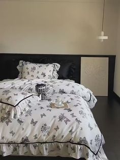 a bed with white and black comforters in a bedroom next to a window,