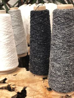 three spools of yarn sitting on top of a wooden table next to each other