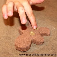 a hand reaching for a cookie shaped like a dog