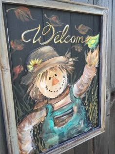 a welcome sign with a scarecrow holding a bird