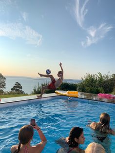 people are in the pool playing with a ball