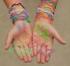 two hands with different colored bracelets on them